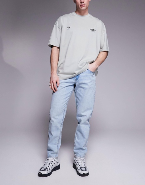 ASOS DESIGN tapered fit jeans in light wash blue
