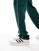 ASOS DESIGN straight leg sweatpants in green with contrast yellow piping
