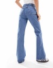 ASOS DESIGN Petite mid rise flare jeans in mid blue