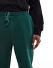 ASOS DESIGN straight leg sweatpants in green with contrast yellow piping